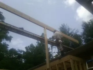 Carpenter setting a ridge beam over a new addition frame — Ice Dam Removal by Roofing Brothers in Gloucester Point