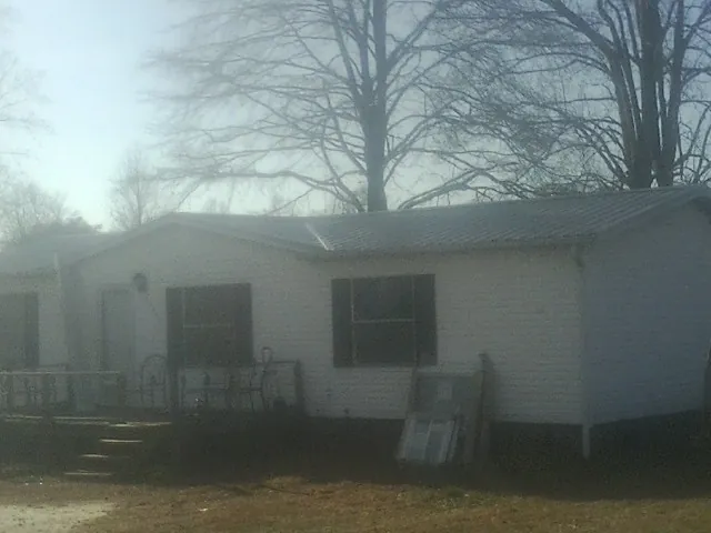 New metal roof on a white painted brick home on a foggy morning in Gloucester Point